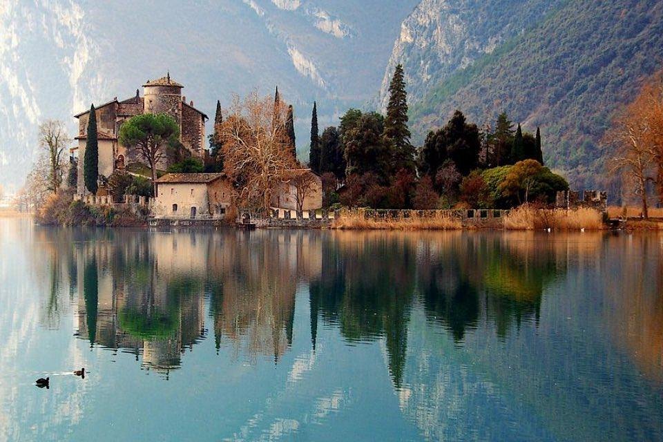 Lake Trasimeno with castle and mountains reflected in still water